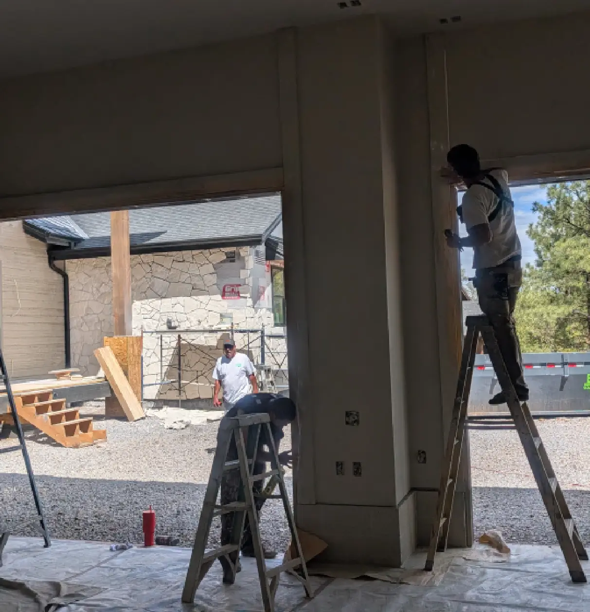 Workers renovating a building interior with construction materials outside.
